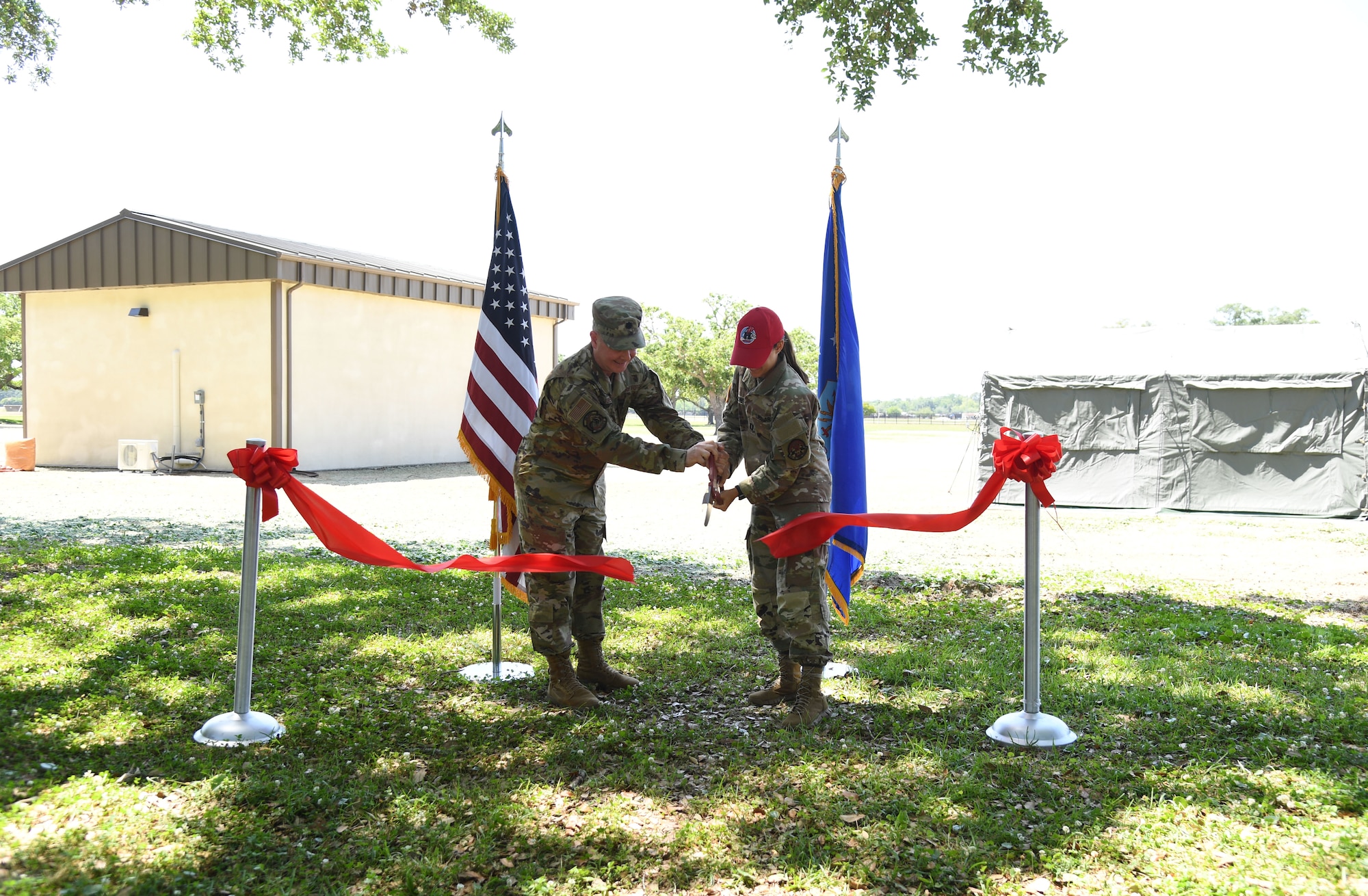 U.S. Air Force Lt. Col. Tobiah Jones, 338th Training Squadron commander, and U.S. Army Capt. Olivia Theodore, 823rd Red Horse Squadron project engineer, Hurlburt Field, Florida, participates in an Air Expeditionary Force Ribbon Cutting Ceremony behind Jones Hall at Keesler Air Force Base, Mississippi, May 4, 2022. The AEF Training Area supports more than 700 students annually for the Radio Frequency Operations Apprentice Course. (U.S. Air Force photo by Kemberly Groue)