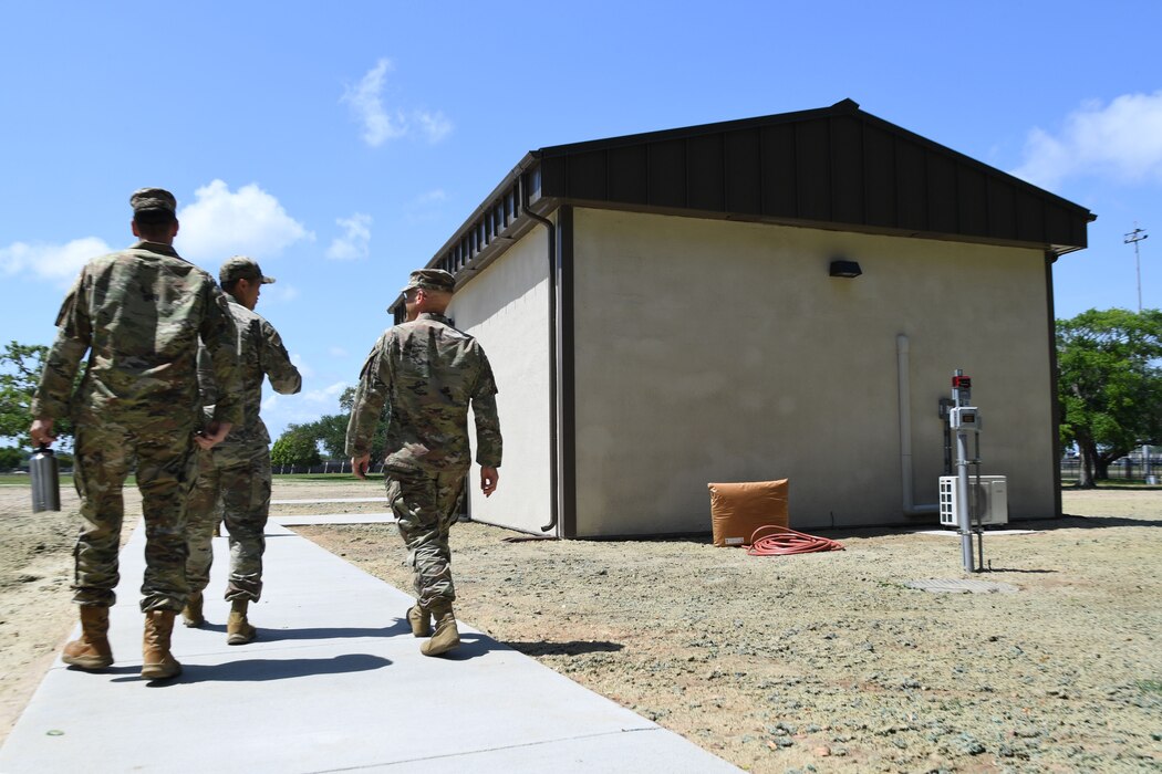 Keesler personnel walk towards a new training building during the Air Expeditionary Force Ribbon Cutting Ceremony behind Jones Hall at Keesler Air Force Base, Mississippi, May 4, 2022. The AEF Training Area supports more than 700 students annually for the Radio Frequency Operations Apprentice Course. (U.S. Air Force photo by Kemberly Groue)