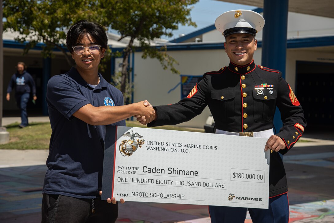 U.S. Marine Corps Sgt. Josue Fragoso, a recruiter with Recruiting Sub-Station South Bay, Recruiting Station Orange County, congratulates Caden Shimane, a senior at North High School, during a Naval Reserve Officer Training Corps Scholarship check presentation in Torrance, California on April 19, 2022. Shimane plans to attend University of California, Davis and will be majoring in economics before commissioning as a Marine Corps officer. (U.S. Marine Corps photo by Cpl. Emely Gonzalez)