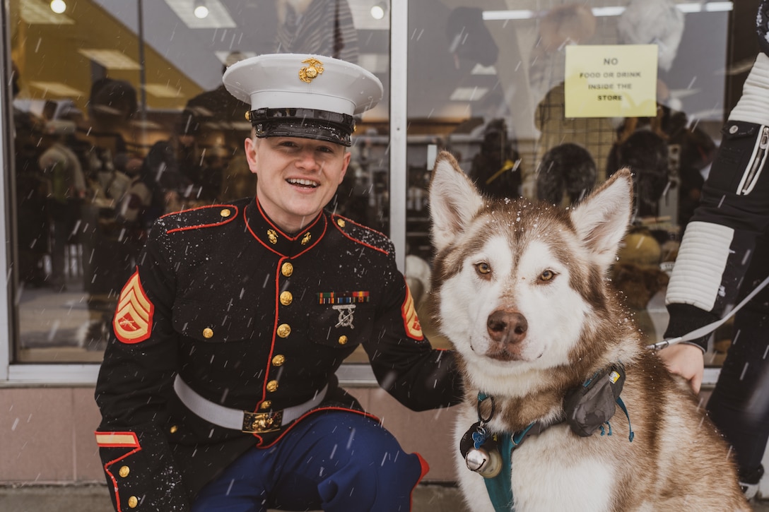 U.S. Marine Corps Staff Sgt. Jacob Bellis, the staff non-commissioned officer in charge of Recruiting Sub-Station Anchorage, Recruiting Station Portland, poses for a photo with a husky during the 2022 Iditarod Trail Sled Dog Race in Anchorage, Alaska on March 5, 2022. The Marines had the opportunity to conduct a swear-in ceremony under the start banner and educate spectators about the opportunities the Marine Corps has to offer. The Iditarod is an annual race in Alaska that stretches over 900 miles, starting in Anchorage and ending in Nome. (U.S. Marines Corps photo by Sgt. Menelik Collins)