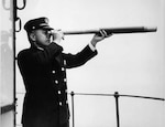 Photograph of Keeper Samuel Amalu scanning the horizon from one of his many lighthouses. (U.S. Coast Guard Collection)