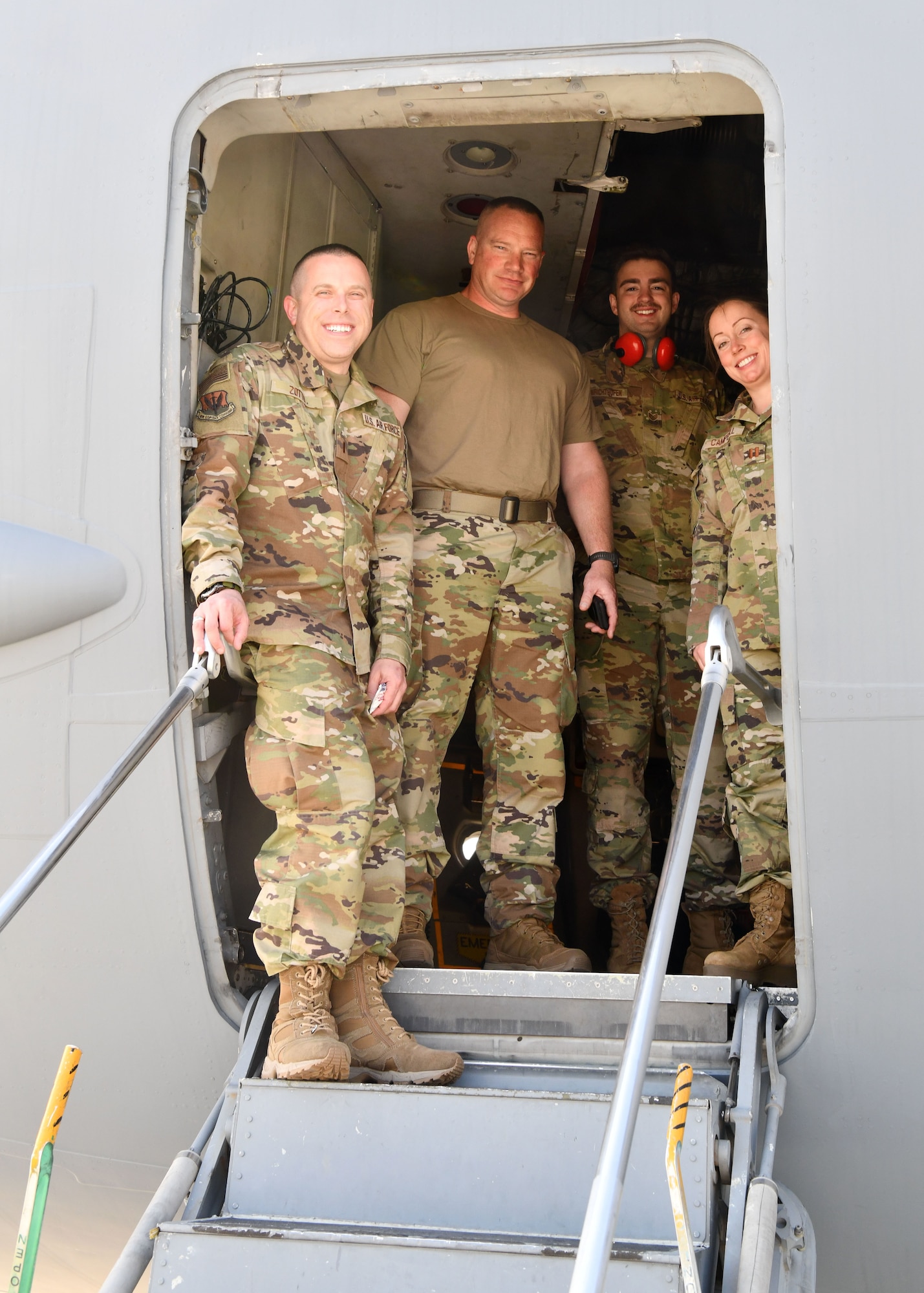 1st Lt. Vinny Zotto, 104 MDG supervisor, Master Sgt. Michael Hoar, 104th Fighter Wing first sergeant., Tech. Sgt. Austin Von Richthofen, 104 MDG aerospace medical technician and Capt. Krista Campbell, 104 MDG nurse stand in the doorway of a C-17 Globemaster III during refueling at Travis Air Force Base, California, April 23, 2022. These members are traveling to Tripler Army Medical Center in Honolulu, Hawaii to complete training requirements. (U.S. Air National Guard Photo by Senior Airman Camille Lienau)