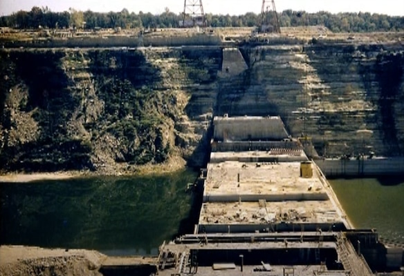 a construction site showing concrete monoliths being constructed across a slow moving river