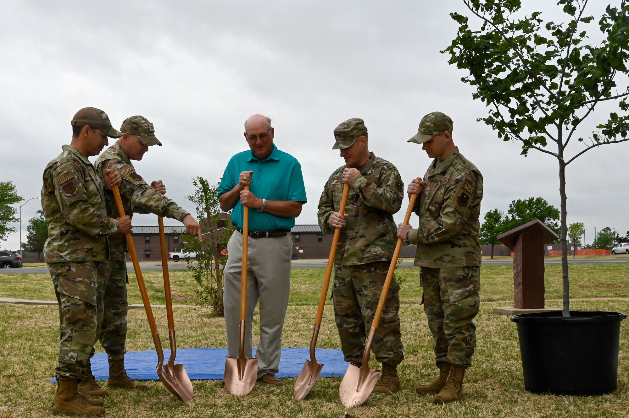 U.S. Air Force Col. Blaine Baker, 97th Air Mobility Wing commander, alongside other Airmen and Robert Garrison, Mayor of Altus, points to a ground-breaking location for a new eastern redbud tree at Altus Air Force Base, Oklahoma, May 2, 2022. The leaders planted the tree in Wings of Freedom park alongside historic static aircraft. (U.S. Air Force photo by Senior Airman Kayla Christenson)