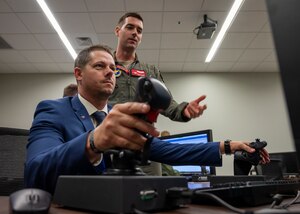 U.S. Air Force Capt. Brian “Nova” Kane, 56th Training Squadron F-35A Lightning II aircraft instructor pilot, directs Michael Tree, military and veterans’ community liaison to U.S. Rep. Debbie Lesko, on the use of an F-35A Hands-On Throttle and Stick simulator May 4, 2022, at Luke Air Force Base, Arizona.