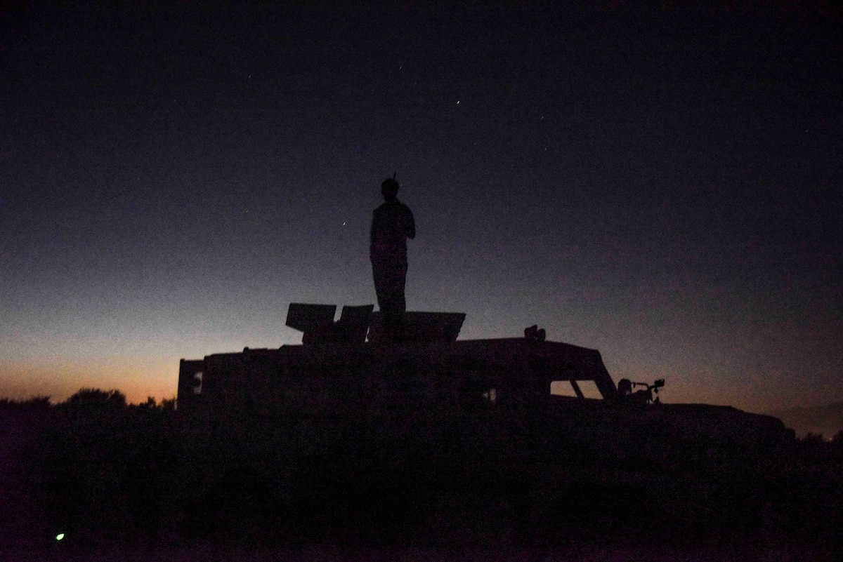 A photo of a man standing on top of a truck.