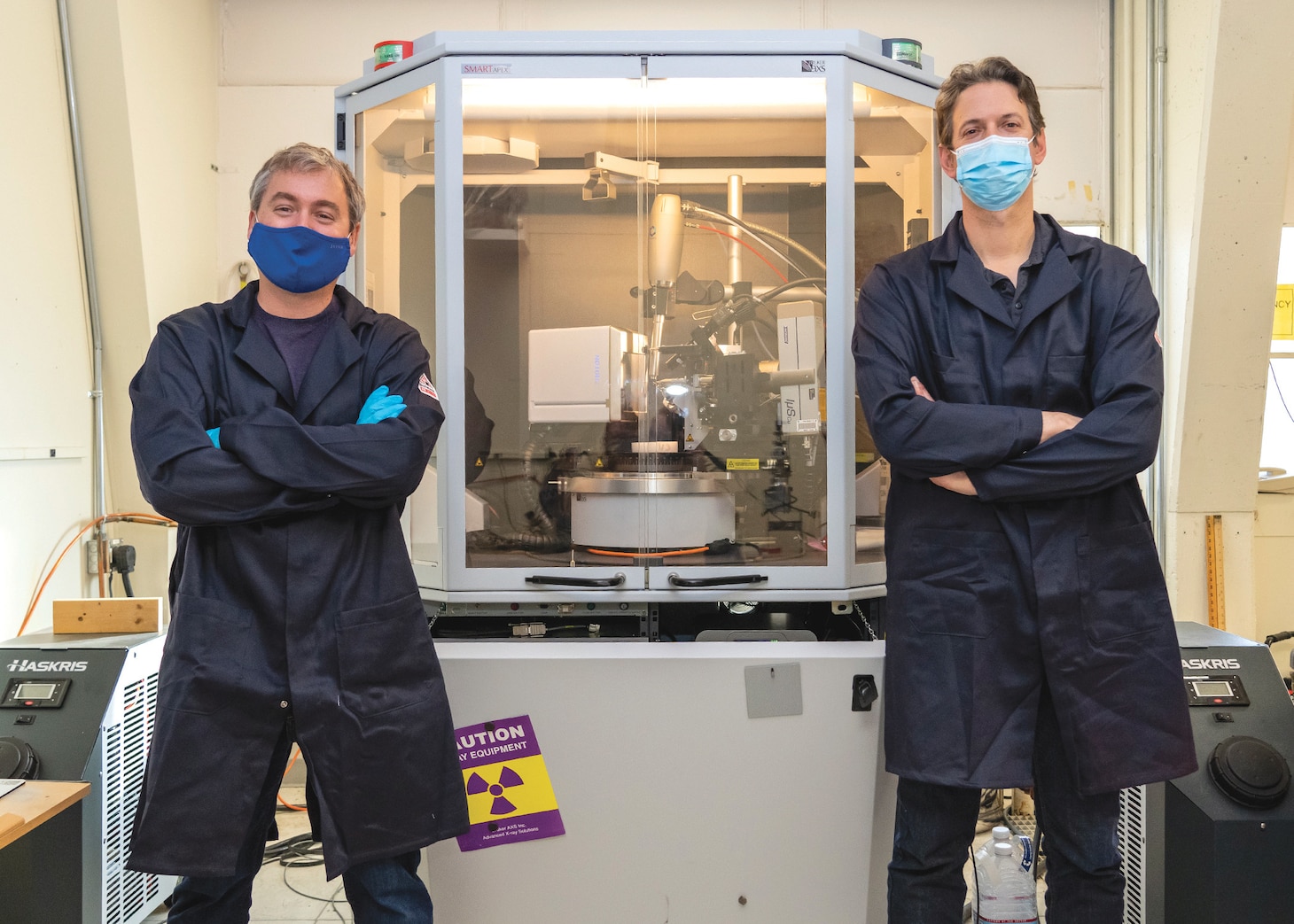 Dr. Randall McClain, left, and Dr. Ben Harvey stand in front of a single crystal X-ray diffractometer, which is used to determine the chemical structure of molecules.