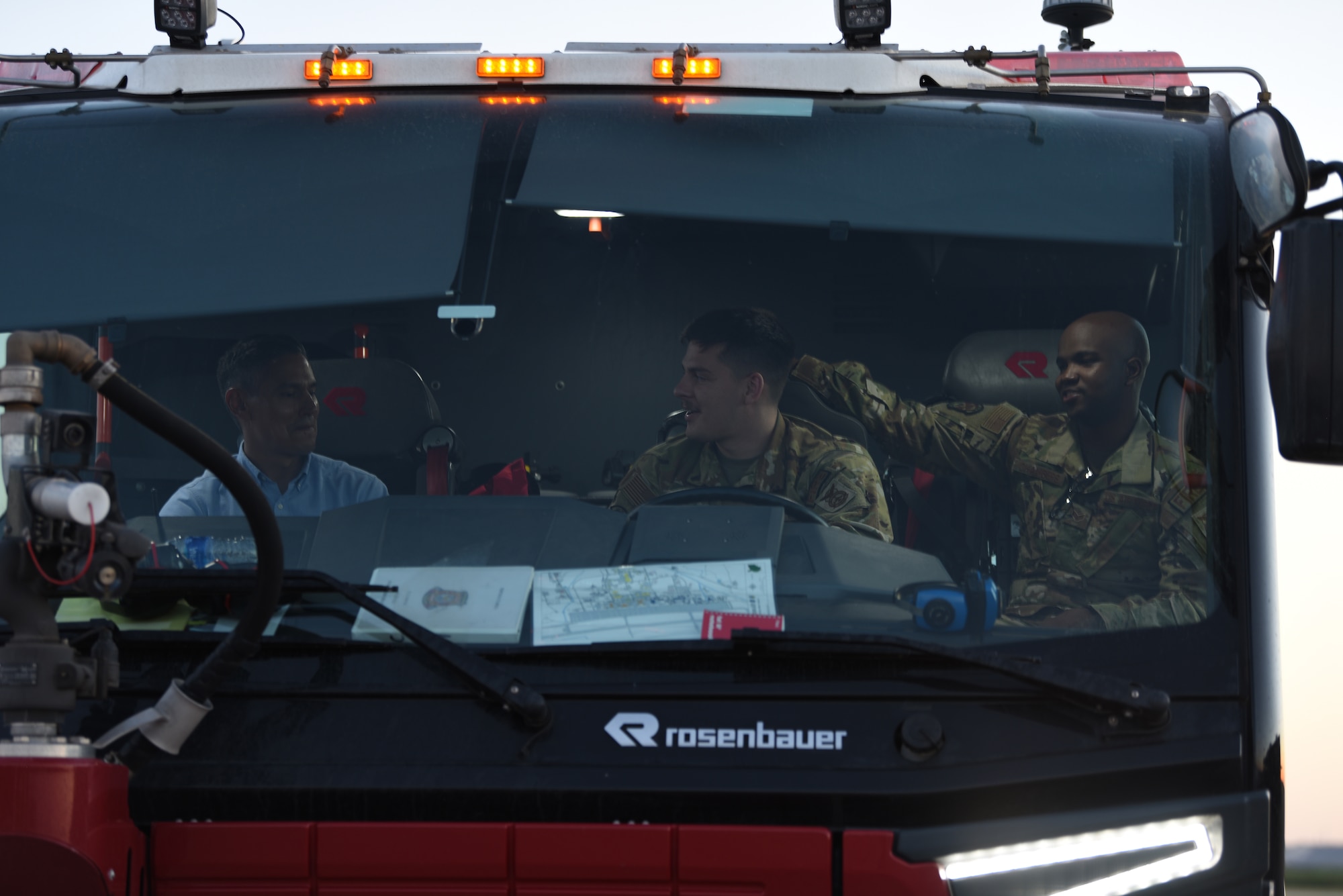 Dyess Fire Department Airmen speak to Col. David Martinez, 489th Bomb Group commander, during the Night Sortie Social at Dyess Air Force Base, Texas, May 5, 2022. The Dyess Fire Department hosted displays at the event to educated base leadership, honorary commanders and civic leaders about their equipment, personnel and how they keep Dyess residents safe. (U.S. Air Force photo by Staff Sgt. Holly Cook)