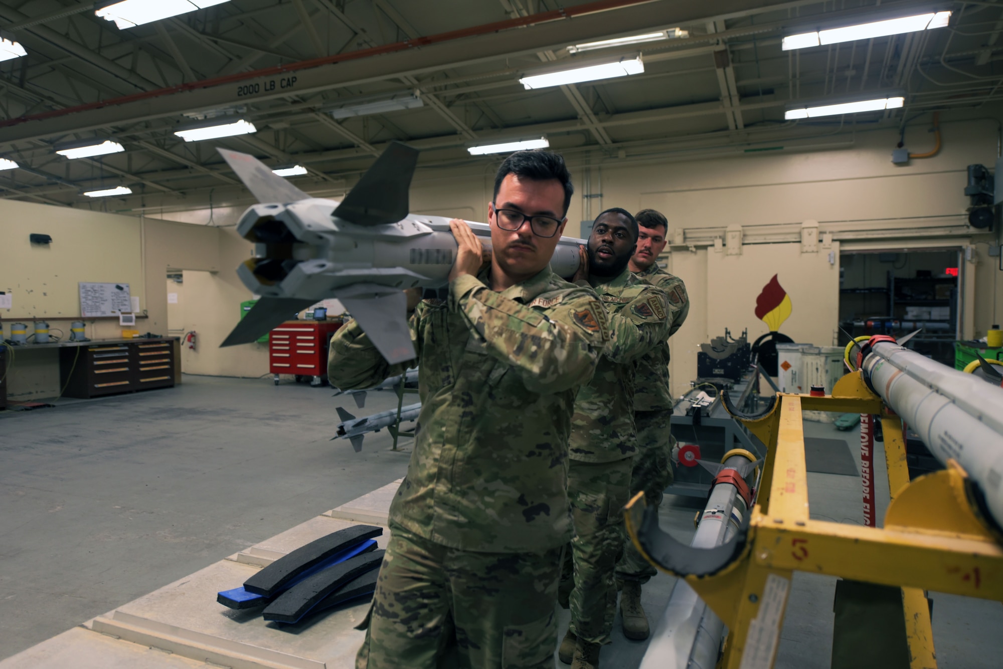 Airmen lift a missile