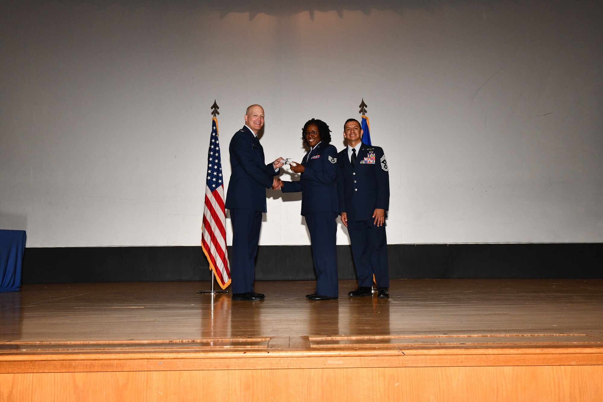 U.S. Air Force Staff Sgt. Sequoia Vandenburg, 97th Medical Group dental assistant, accepts a Community College of the Air Force (CCAF) degree from the 97th Air Mobility Wing command team during a CCAF graduation at Altus Air Force Base, Oklahoma, April 29, 2022. Twenty-five  Airmen received their degrees during the ceremony. (U.S. Air Force photo by Airman 1st Class Miyah Gray)