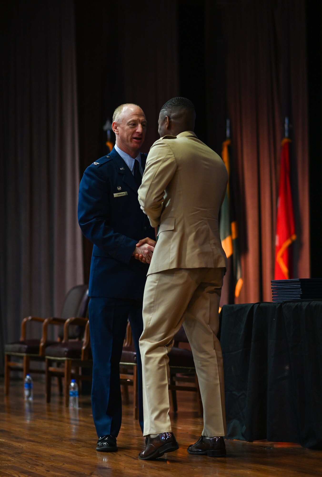 U.S. Air Force Col. Seth Graham, 14th Flying Training Wing commander, shakes hands with 1st Lt. Wayne Morgan, Jamaican Defence Force pilot, at the graduation ceremony of Undergraduate Pilot Training Class 22-09 on April 6, 2022, at Columbus Air Force Base, Miss. The 14th Flying Training Wing trains pilots from various allied countries across the globe. (U.S. Air Force photo by Senior Airman Davis Donaldson)