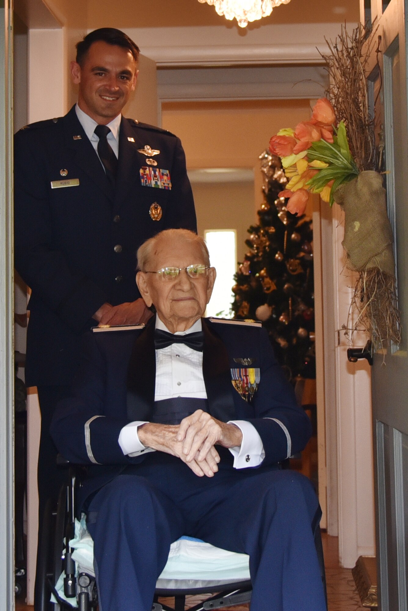 Col. Rubio stands behind Maj. Thomas, in a wheelchair, in a doorway.