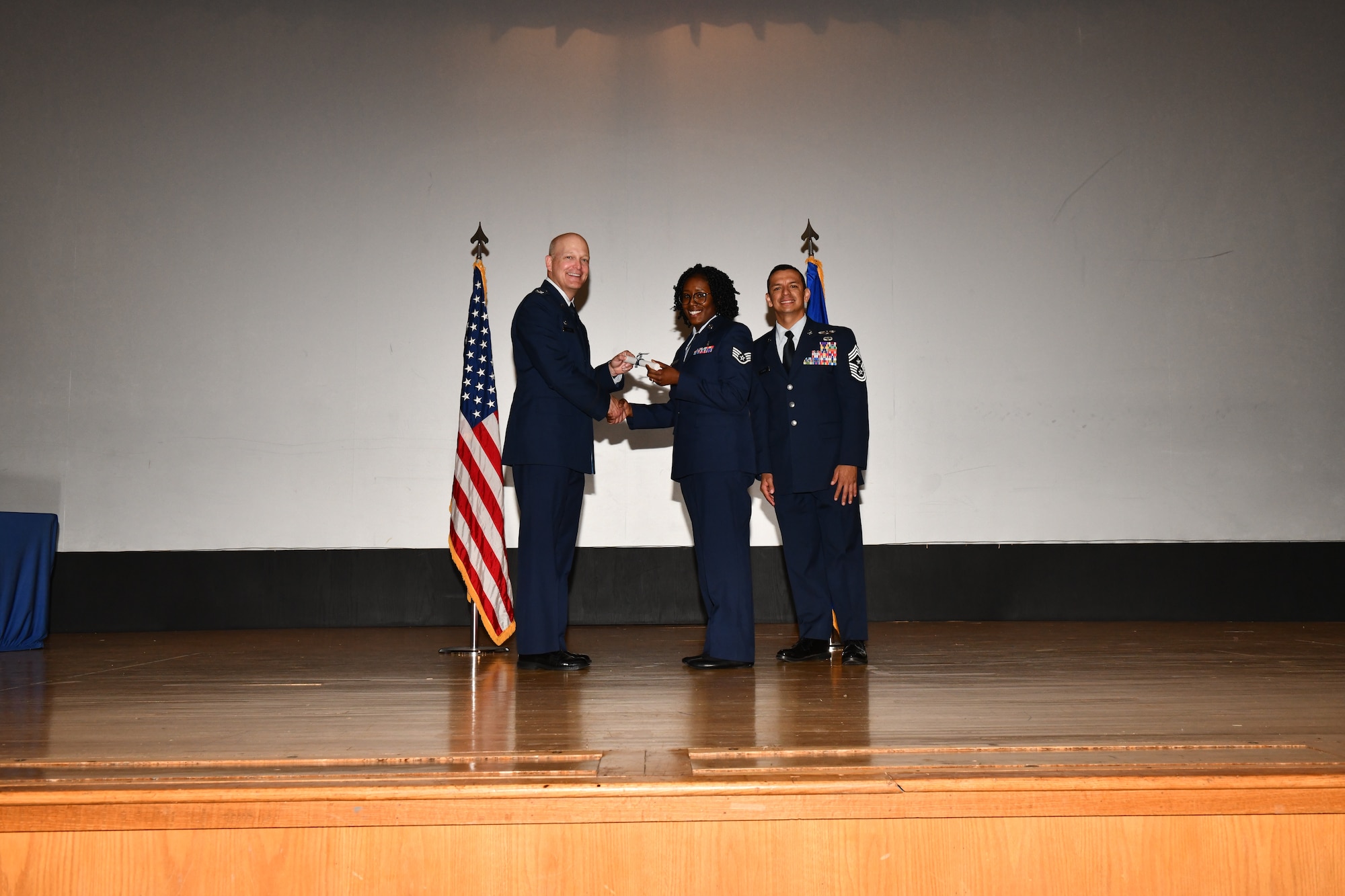 U.S. Air Force Staff Sgt. Sequoia Vandenburg, 97th Medical Group dental assistant, accepts a Community College of the Air Force (CCAF) degree from the 97th Air Mobility Wing command team during a CCAF graduation at Altus Air Force Base, Oklahoma, April 29, 2022. Twenty-five  Airmen received their degrees during the ceremony. (U.S. Air Force photo by Airman 1st Class Miyah Gray)