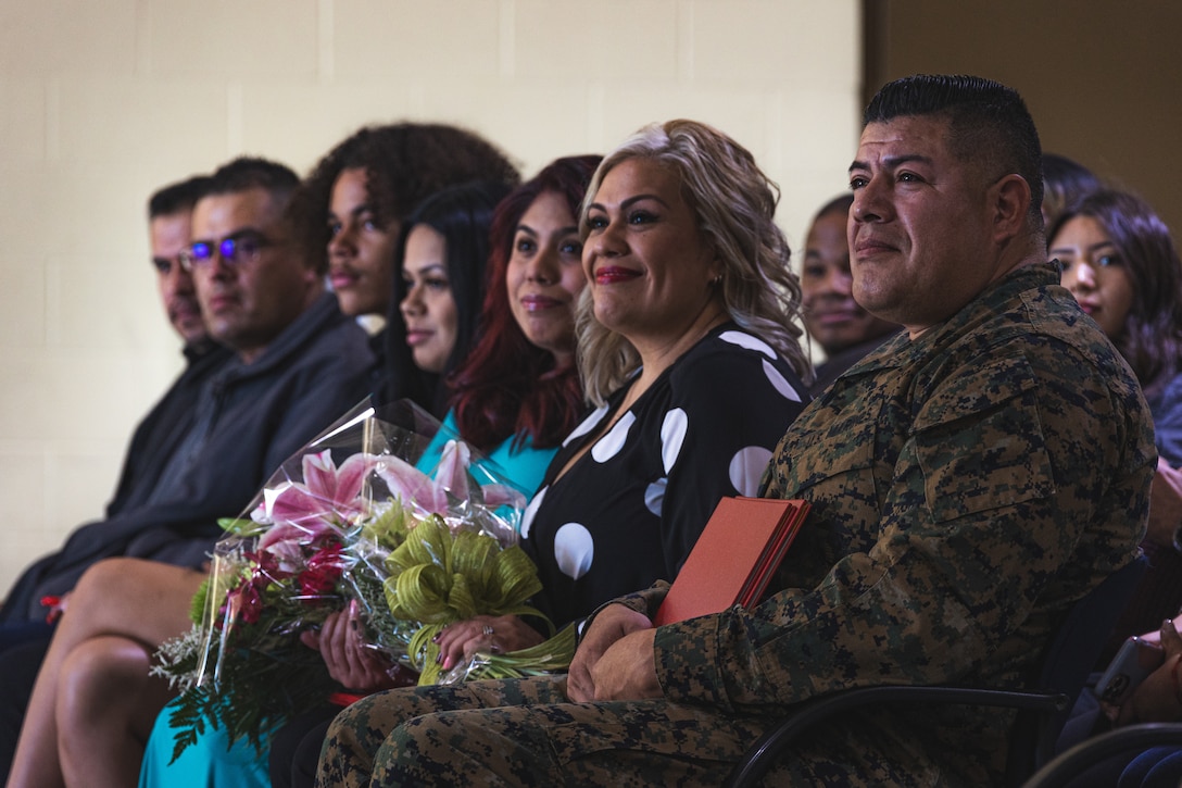 U.S. Marine Corps Sgt. Maj. Arturo Cisneros, the Recruiting Station Riverside sergeant major, and his family listen to the retiring officer’s speech during his retirement ceremony at March Air Reserve Base in Riverside, California on Dec. 17, 2021. The retirement ceremony was held to recognize Cisneros’ 26 years of faithful and selfless service. (U.S. Marine Corps photo by Sgt. Christian Cachola)