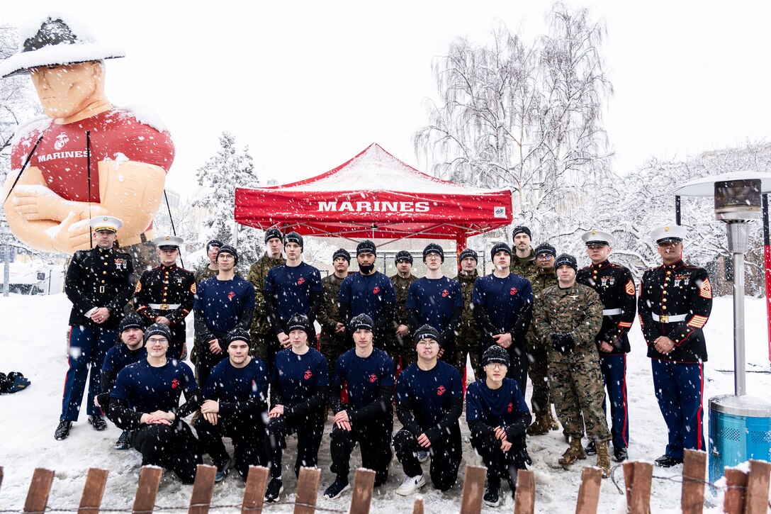 U.S. Marines and poolees with Recruiting Station Portland, pose for a group photo at the 2022 Iditarod Trail Sled Dog Race in Anchorage, Alaska on March 5, 2022. The Marines had the opportunity to conduct a swear-in ceremony under the start banner and educate spectators about the opportunities the Marine Corps has to offer. The Iditarod is an annual race in Alaska that stretches over 900 miles, starting in Anchorage and ending in Nome. (U.S. Marines Corps photo by Sgt. Menelik Collins)