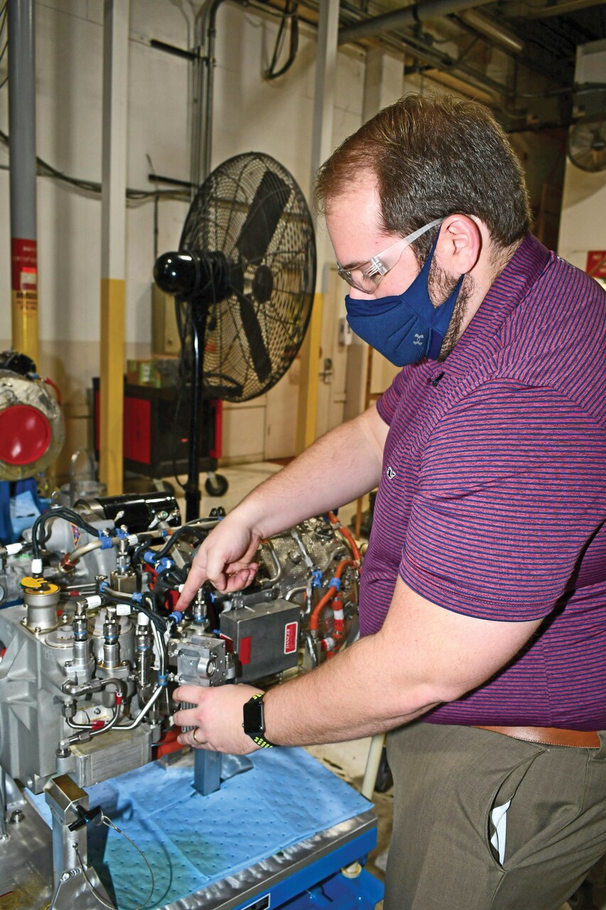 Rob Wansker (right), FRCE V-22 Power and Propulsion Auxiliary Power Unit (APU) senior engineer, and Derek Britton, mechanical engineer in the APU group, examine a clutch servo-valve filter for a V-22 APU. The APU group recently developed a process to clean and recertify these filters for use after supply issues made the critical part temporarily unavailable to the fleet.