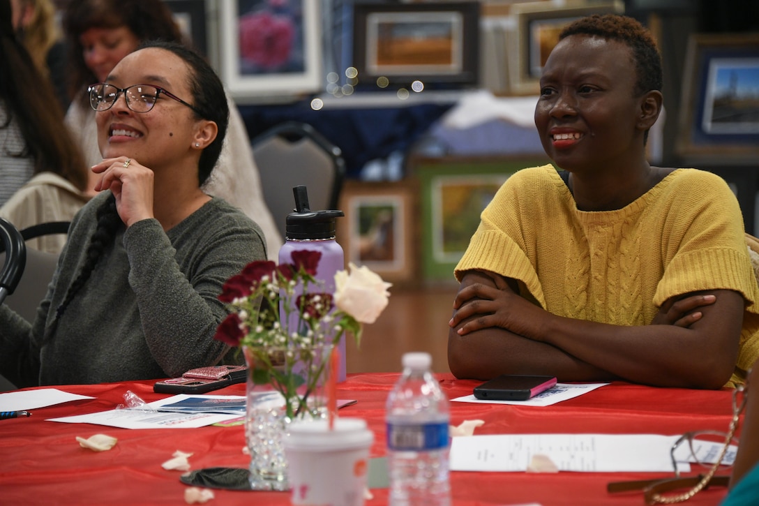 Two attendees of National Capital Region Military Spouse Appreciation Day await the results of a raffle drawing at Joint Base Andrews, Md., May 6, 2022. Blue Star Families contributed dozens of framed art photographs in honor of Military Spouse Appreciation Day. (U.S. Air Force photo by Airman 1st Class Isabelle Churchill)