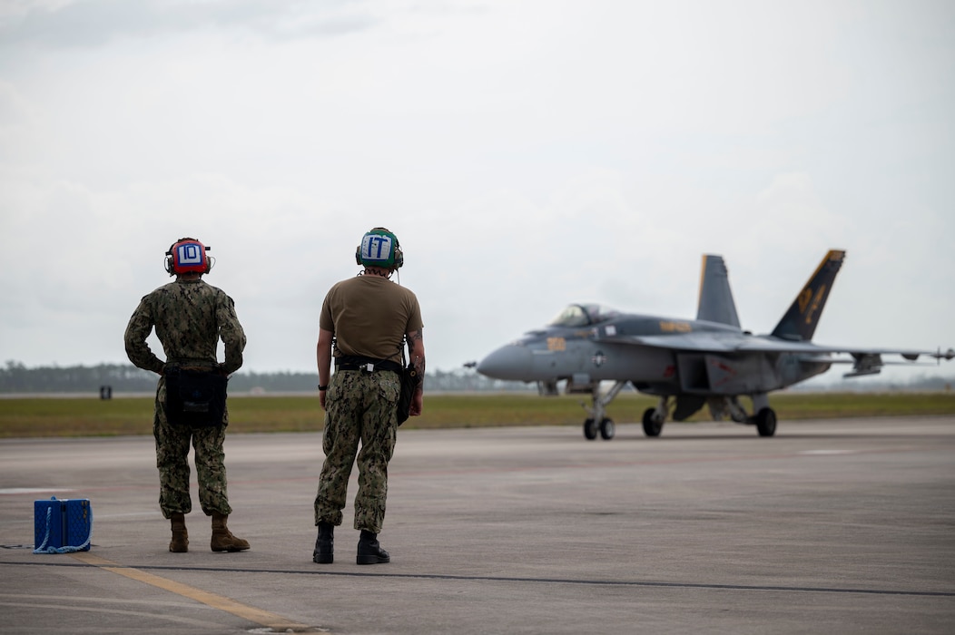 Sailors observe an aircraft taxiing