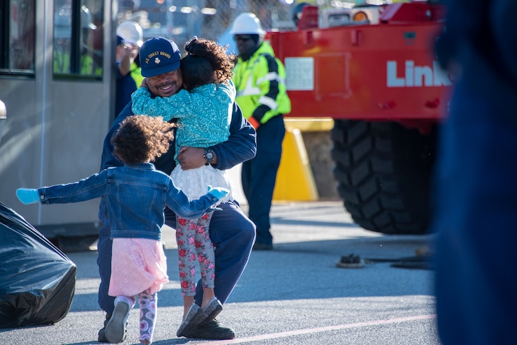 A Coast Guard Cutter Valiant crew member embraces his family Feb. 27, 2020, as he returns home to Naval Station Mayport, Florida. The Valiant crew returned home after completing a nine-week patrol in the Caribbean Sea supporting Joint Interagency Task Force South.