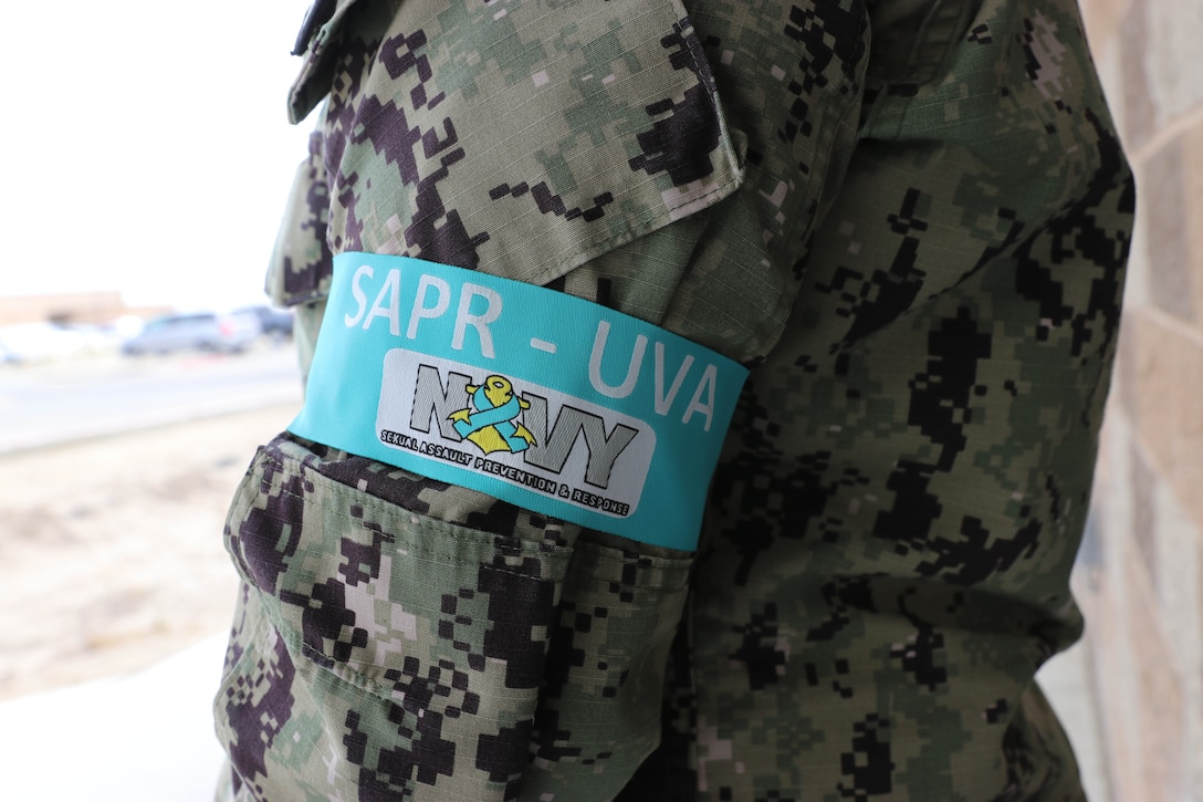 A service member wears a teal armband.