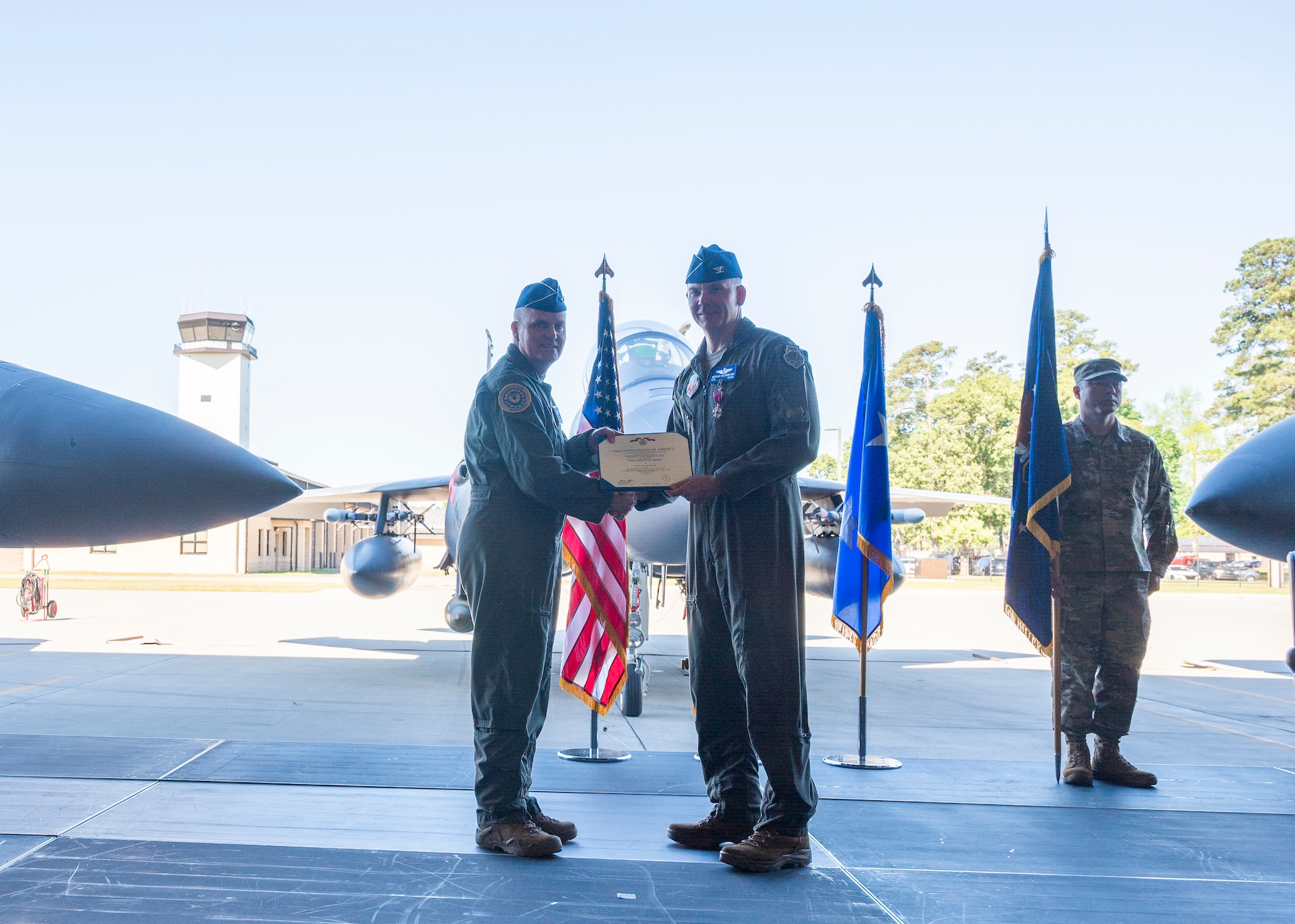 Maj. Gen. Michael G. Koscheski, left, Fifteenth Air Force commander, presents the Legion of Merit citation to Col. Kurt Helphinstine, outgoing 4th Fighter Wing commander, as he relinquishes command of the 4th FW during a Change of Command ceremony at Seymour Johnson Air Force Base, North Carolina, May 11, 2022. Helphinstine was the commander of the 4th FW for approximately two years. (U.S. Air Force photo by Senior Airman Kimberly Barrera)