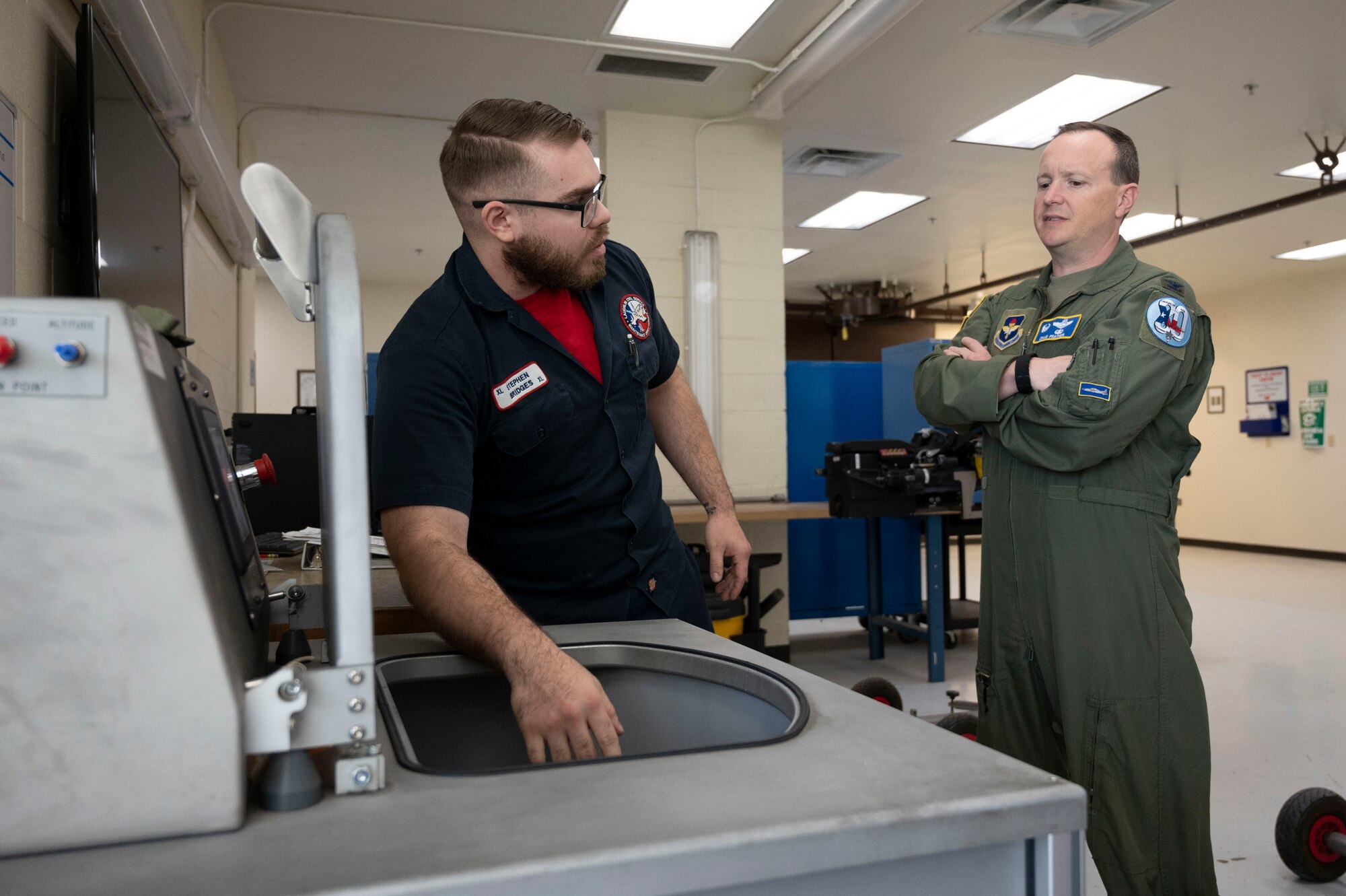 Stephen Bridges, 47th Maintenance Directorate aircraft ordnance technician, shows Col. Craig Prather, 47th Flying Training Wing commander, the operations of a machine he uses to make sure that each ejection seat is successful in its performance at the Egress Shop on Laughlin Air Force Base, Texas, April 8, 2022. Bridges and his coworkers take apart, inspect, test, replace or repair the ejection seats that are in each aircraft at Laughlin daily to keep our pilots safe. (U.S. Air Force photo by Airman First Class Kailee Reynolds)