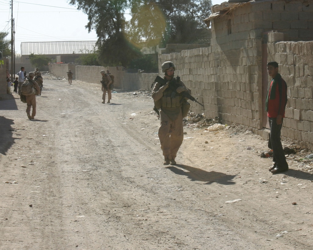 U.S. Marines with 1st Squad, 2nd Platoon, L Company, 3rd Battalion, 3rd Marines, patrol an alleyway in Karmah, Iraq.
