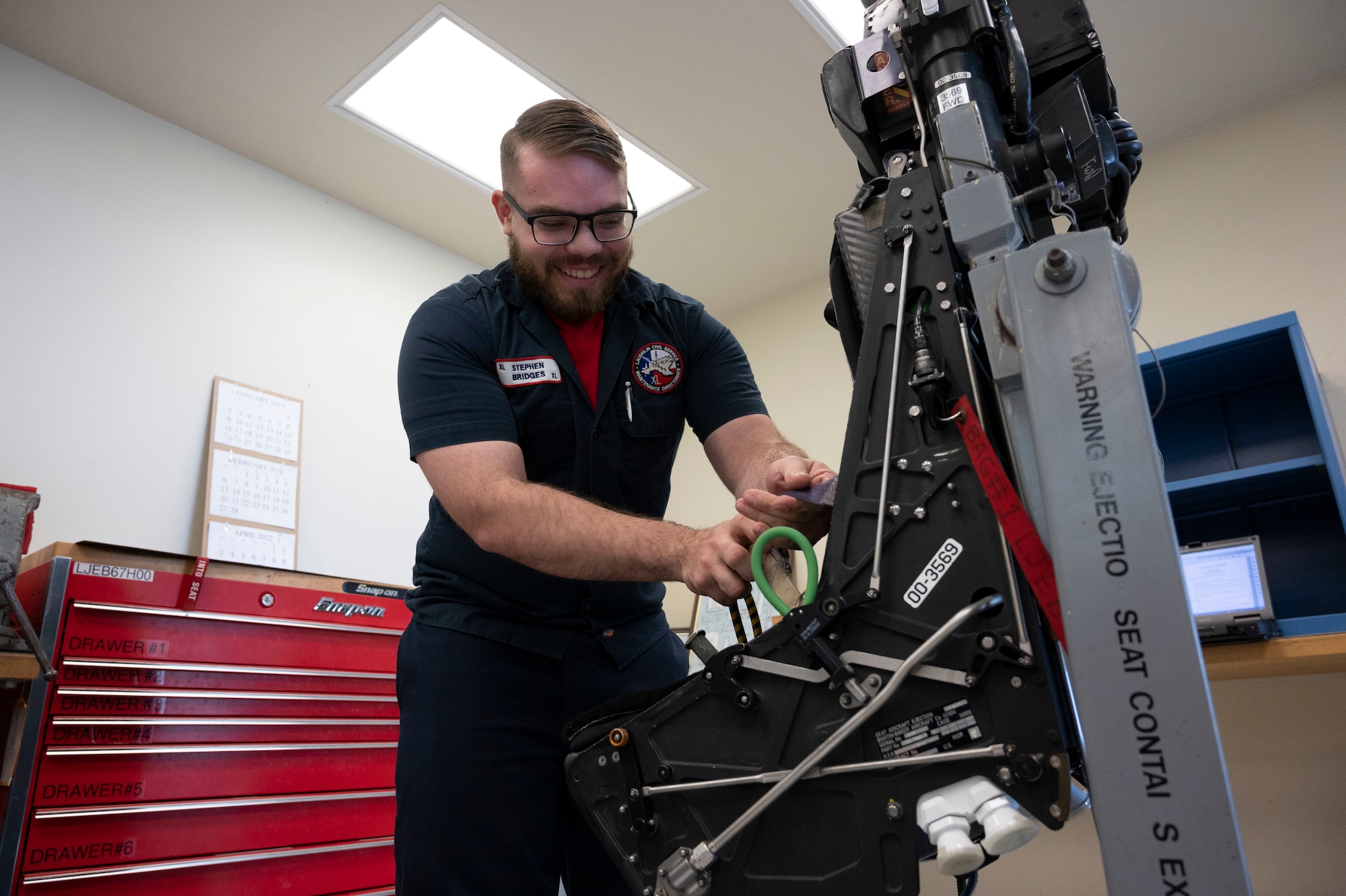 Stephen Bridges, 47th Maintenance Directorate aircraft ordnance technician, works to take apart an ejection seat for an inspection at the Egress Shop at Laughlin Air Force Base, Texas, April 8, 2022. Bridges and his coworkers take apart, inspect, replace or repair the ejection seats that are in each aircraft at Laughlin daily to keep our pilots safe. (U.S. Air Force photo by Airman First Class Kailee Reynolds)
