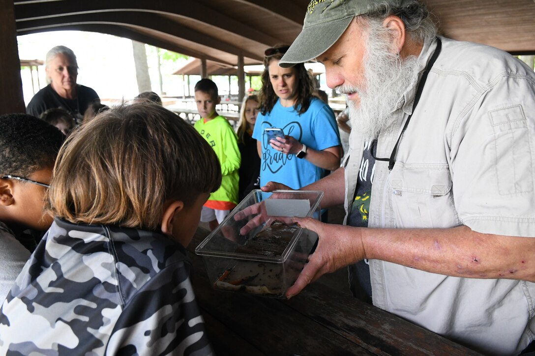 David Withers, a biologist from the Department of Environment and Conservation, shows Union Elementary STEAM students a small salamander habitat after teaching them the importance of hydropower to the local wildlife at the Old Hickory Lake picnic area in Hendersonville, Tennessee on May 4, 2022.