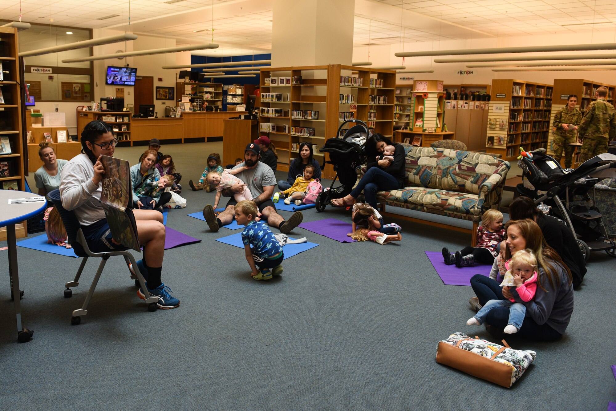 U.S. Air Force Airman 1st Class Melanie Palafox-Silva, 627th Communications Squadron cable and antenna technician, reads a book during McChord Field Library children's story time as part of Asian American and Pacific Islander Heritage Month celebration at Joint Base Lewis-McChord, May 11, 2022. This year's theme, "Advancing Leaders Through Collaboration," recognizes the collective benefits resulting from a spirit of community, cooperation and cultural engagement. (U.S. Air Force photo by Master Sgt. Julius Delos Reyes)