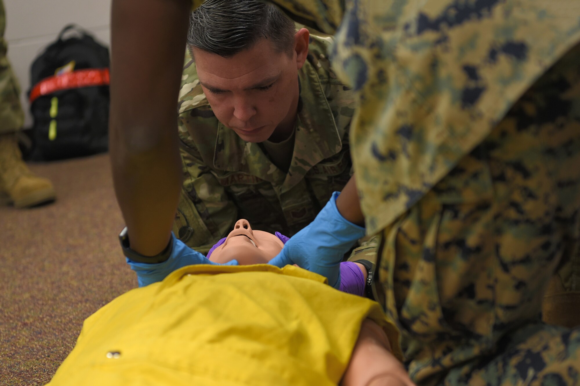 U.S. Air Force Tech Sgt. Brandon Martin, 312th Training Squadron instructor, demonstrates C-spine stabilization for joint service students of the Louis F. Garland Department of Defense Fire Academy at Goodfellow Air Force Base, Texas, May 6, 2022. The students learned Emergency Medical Responder skills before their psychomotor evaluation. (U.S. Air Force photo by Senior Airman Abbey Rieves)