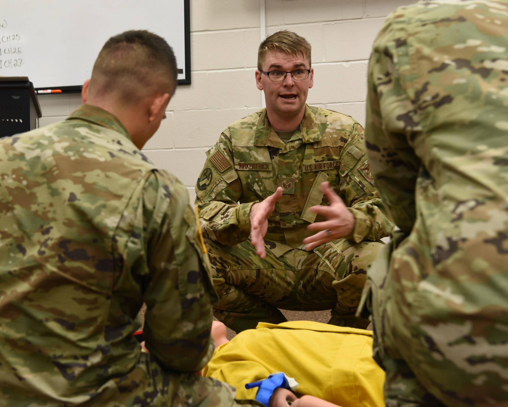 U.S. Air Force Staff Sgt. Robert Kirkpatrick, 312th Training Squadron instructor, spot corrects joint service students during a hands-on learning objective for the Emergency Medical Responder skills prior to their psychomotor evaluation at Goodfellow Air Force Base, Texas, May 6, 2022. The psychomotor skill drill evaluation assessed the student’s ability to conduct C-spin stabilization, bleeding control, and splint fractures. (U.S. Air Force Photo by Senior Airman Abbey Rieves)