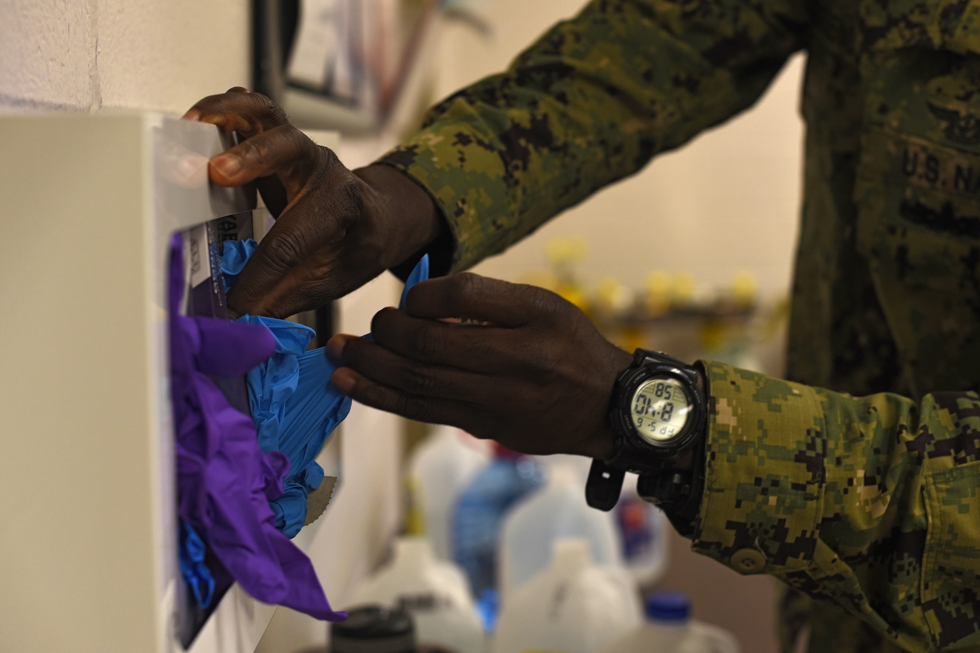 U.S. Navy Petty Officer First Class Janathan Agbenu, 312th Training Squadron student, grabs disposable gloves for his Emergency Medical Responder psychomotor evaluation at Goodfellow Air Force Base, Texas, May 6, 2022. Agbenu practiced using personal protective equipment for health and safety interests and to prevent contact with potentially hazardous bodily fluid.  (U.S. Air Force photo by Senior Airman Abbey Rieves)