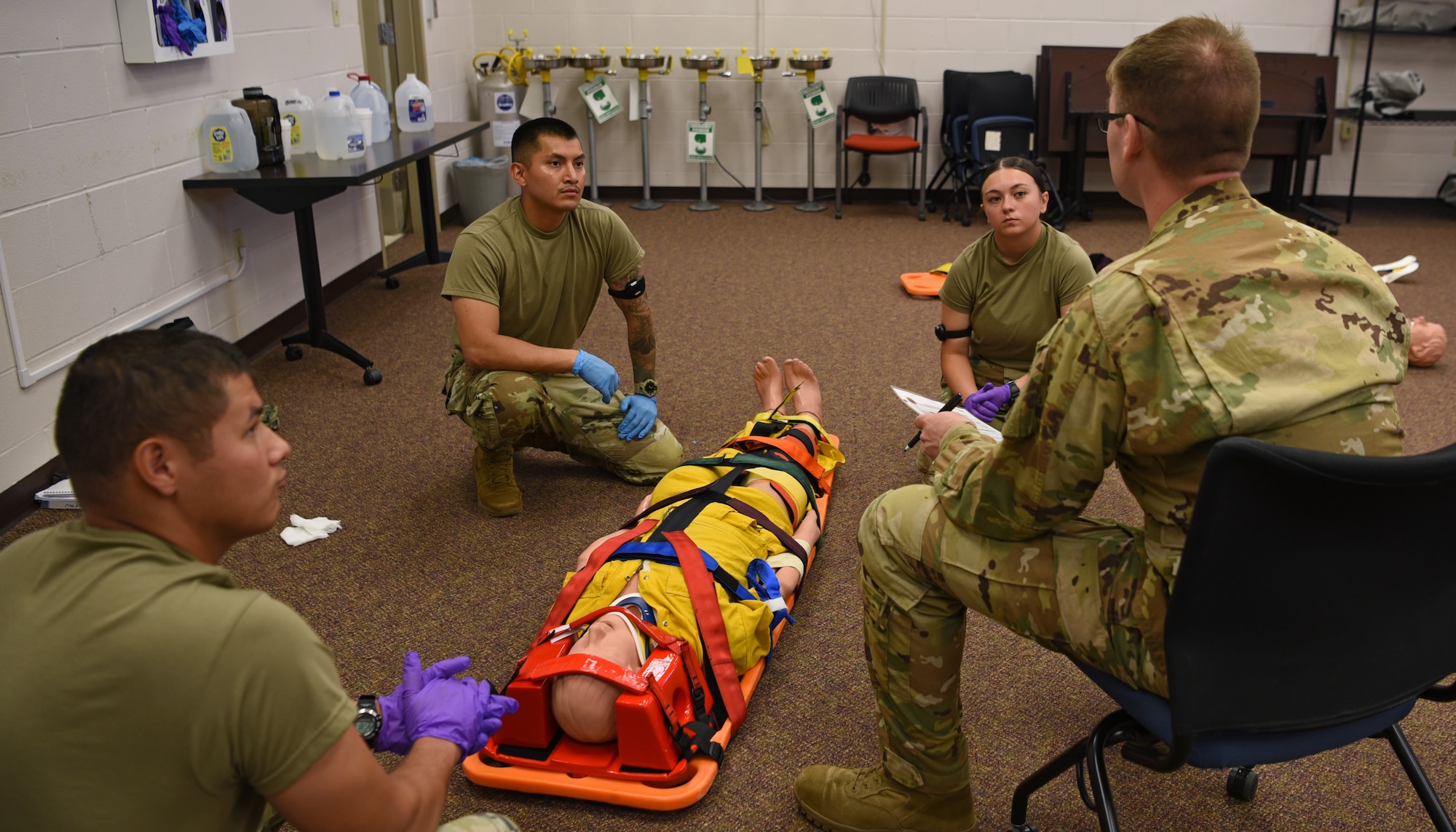 U.S. Air Force Staff Sgt. Robert Kirkpatrick, 312th Training Squadron instructor, provides feedback to his joint service student on their Emergency Medical Responder psychomotor skills evaluation, Goodfellow Air Force Base, Texas, May 6, 2022. Kirkpatrick replaced lecture instruction with coaching and mentoring techniques to build trust with his students and advance training. (U.S. Air Force photo by Senior Airman Abbey Rieves)