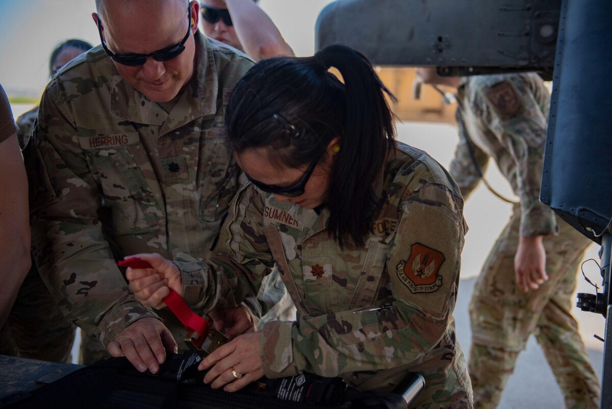 U.S. Air Force Lt. Col. Cordy Herring, 39th Health Care Operations Squadron laboratory officer in charge, and Maj. Shaoping Sumner, 39th Medical Group diagnostics and therapeutics flight commander, fasten a litter to a UH-60 Black Hawk helicopter during the first combined Medic-X and Tactical Combat Casualty Care course hosted by the 39th Medical Group at Incirlik Air Base, Turkey, April 23, 2022. The five-day course integrated multi-capable airman concepts into the existing TCCC curriculum to prepare all medics for prolonged field care. The Air Force Medical Service tasked the 39th MDG to beta test a combined curriculum making this the first training of its kind in the Air Force. (U.S. Air force photo by Staff Sergeant Gabrielle Winn)