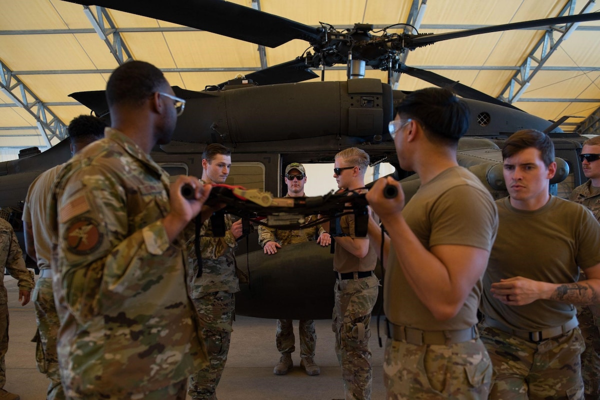 Tactical Combat Casualty Care students from various units across Incirlik Air Base load a litter onto a UH-60 Black Hawk helicopter during the first combined Medic-X and TCCC course hosted by the 39th Medical Group at Incirlik Air Base, Turkey, April 23, 2022. The five-day course integrated multi-capable airman concepts into the existing TCCC curriculum to prepare all medics for prolonged field care. The Air Force Medical Service tasked the 39th MDG to beta test a combined curriculum making this the first training of its kind in the Air Force. (U.S. Air force photo by Staff Sergeant Gabrielle Winn)