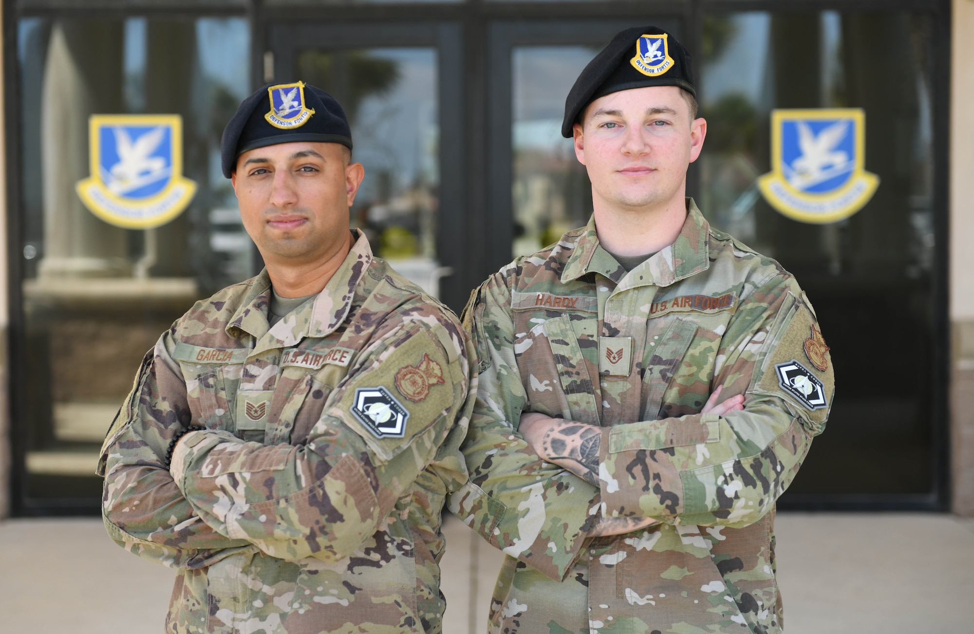 U.S. Air Force Tech. Sgt. Urich Garcia and U.S. Air Force Staff Sgt. Brian Hardy, 45th Security Forces Squadron supra coders, stand outside the 45th SFS building at Patrick Space Force Base, Fla., April 25, 2022. Supra coders have to complete a software development bootcamp that teaches full-stack javascript development and application deployment before receiving the title of supra coder.