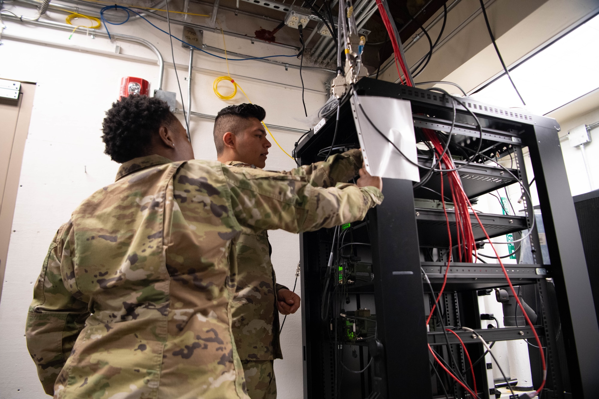 Airman 1st Class Savannah Wilson, 608th Air Communications Squadron radio frequency technician, and Airman 1st Class Tyler Fajardo, 608th ACOMS radio frequency technician, perform a radio check and network test in the 8th Air Force attic. These tests ensure two-way communication is seamless in a time of need. (U.S. Air Force photo by Staff Sgt. Bria Hughes)