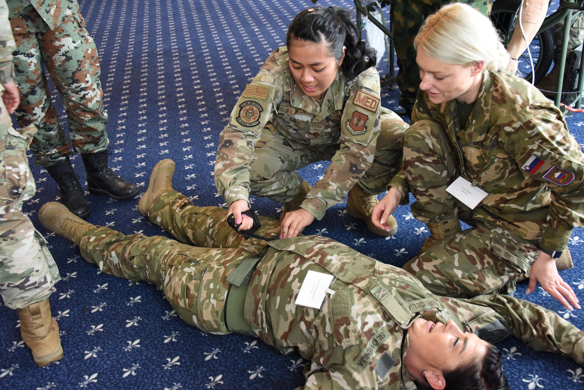 U.S. Air Force Maj. Annalynn Pilarca, 86th Medical Group emergency room critical care nurse, demonstrates proper application of a pelvic binder to delegates from Slovenia during U.S. Air Forces in Europe - Air Forces Africa’s European-African Military Nursing Exchange conference at Ramstein Air Base, Germany, May 10, 2022.