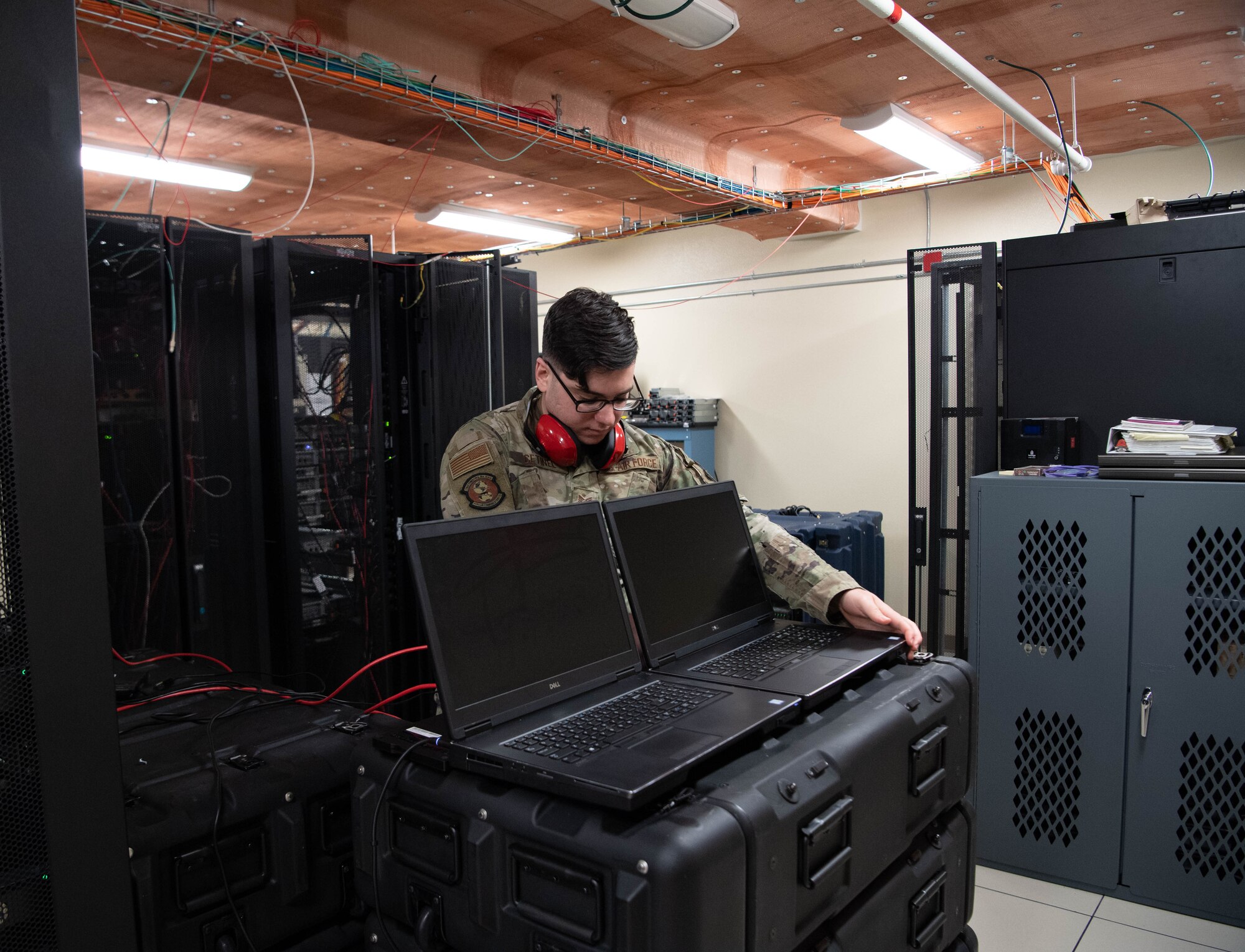 Staff Sgt. Jon Cetinel, 608th Air Communications Squadron cyber defense supervisor, sets up connections for laptops as part of the cyber vulnerability assessment-hunter weapon system kit. This is key to making sure all platforms and cables are connected before powering on the system. (U.S. Air Force photo by Staff Sgt. Bria Hughes)