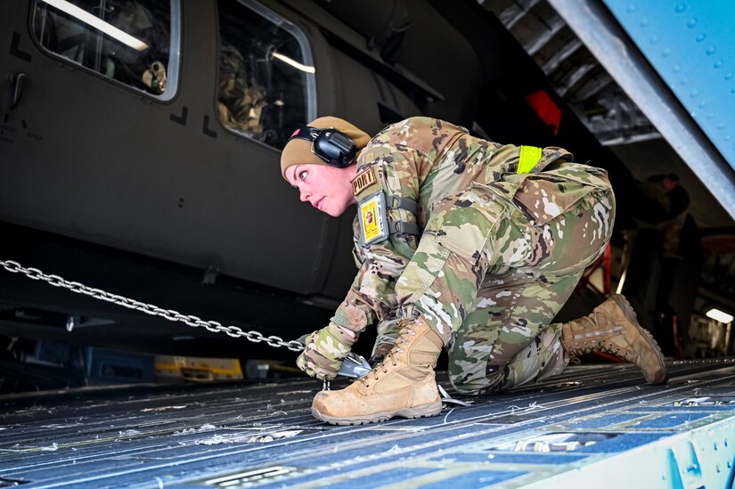 U.S. Air Force Tech. Sgt. Jessica Hernandez, 305th Aerial Port Squadron, air transportation specialist, secures a UH-60M Blackhawk assigned to the 150th Aviation Regiment upload onto a C-17 Globemaster III on May 6, 2022, at Joint Base McGuire-Dix-Lakehurst, N.J. The Black Hawk offers pilots seats that are protected with heavy armor, and an armored fuselage capable of withstanding hits from guns with up to 23mm shells. It can also operate safely in the majority of severe weather conditions due to its wide array of advanced avionics.