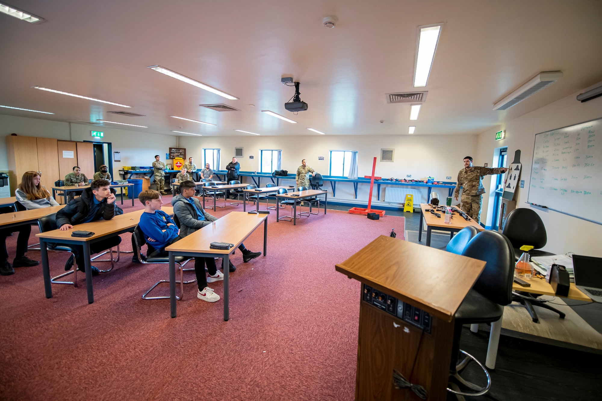 An Airman from the 423d Security Forces Squadron briefs local U.K. students on weapons safety at RAF Molesworth, England, May 10, 2022. The 423d SFS taught students from Huntingdon’s St. Peter’s school about weapons safety and self defense techniques as part of a mentorship program aimed at strengthening the relationship between the 501st Combat Support Wing and local community. (U.S. Air Force photo by Staff Sgt. Eugene Oliver)