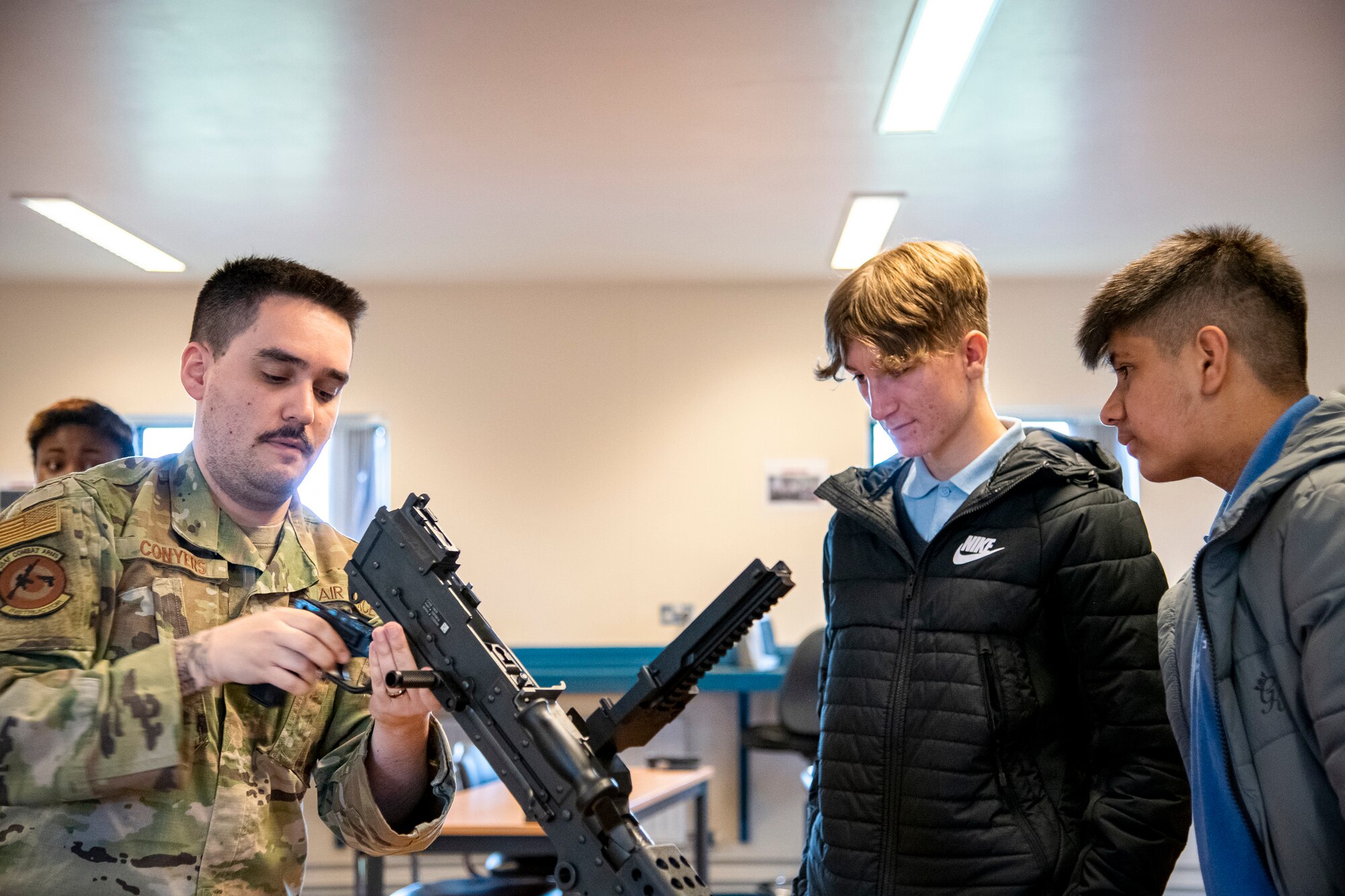 Staff Sgt. Keith Conyers, left, 423d Security Forces Squadron combat arms instructor, demonstrates assembly of a M240B machine gun to local UK student at RAF Molesworth, England, May 10, 2022. The 423d SFS taught students from Huntingdon’s St. Peter’s school about weapons safety and self defense techniques as part of a mentorship program aimed at strengthening the relationship between the 501st Combat Support Wing and local community. (U.S. Air Force photo by Staff Sgt. Eugene Oliver)