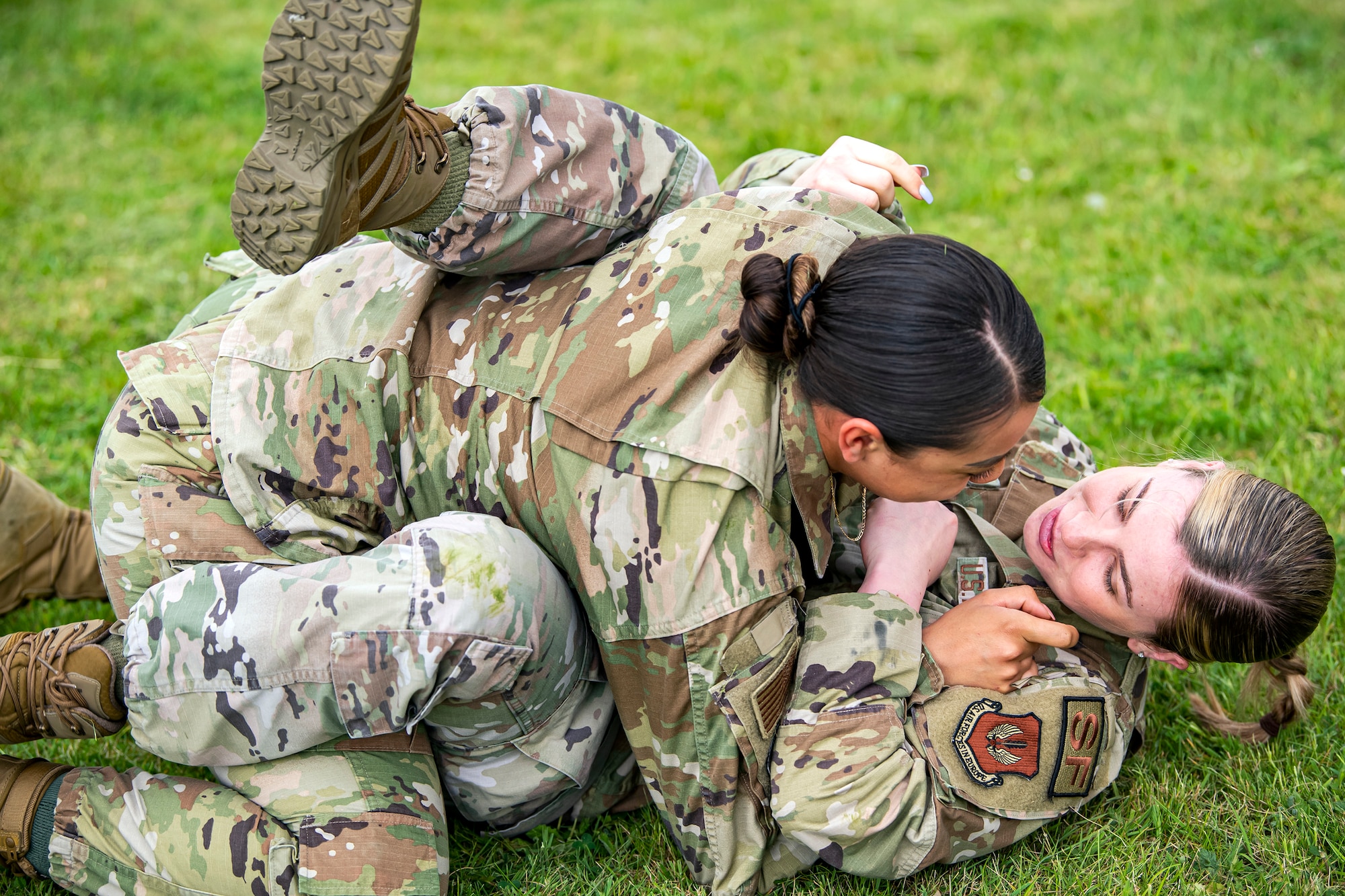 Airman 1st Class Helen Lopez, left, 423d Security Forces Squadron installation patrolman, and Airman 1st Class Sierra Capobianco, base defense operations center controller, demonstrate grappling at RAF Molesworth, England, May 10, 2022. The 423d SFS taught students from Huntingdon’s St. Peter’s school about weapons safety and self defense techniques as part of a mentorship program aimed at strengthening the relationship between the 501st Combat Support Wing and local community. (U.S. Air Force photo by Staff Sgt. Eugene Oliver)