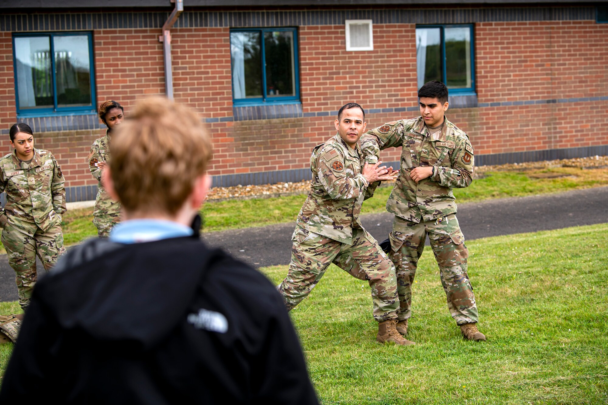 Master Sgt. Christian Navarro Salazar, center left, 423d Security Forces Squadron logistics and readiness section chief, demonstrates self defense techniques at RAF Molesworth, England, May 10, 2022. The 423d SFS taught students from Huntingdon’s St. Peter’s school about weapons safety and self defense techniques as part of a mentorship program aimed at strengthening the relationship between the 501st Combat Support Wing and local community. (U.S. Air Force photo by Staff Sgt. Eugene Oliver)