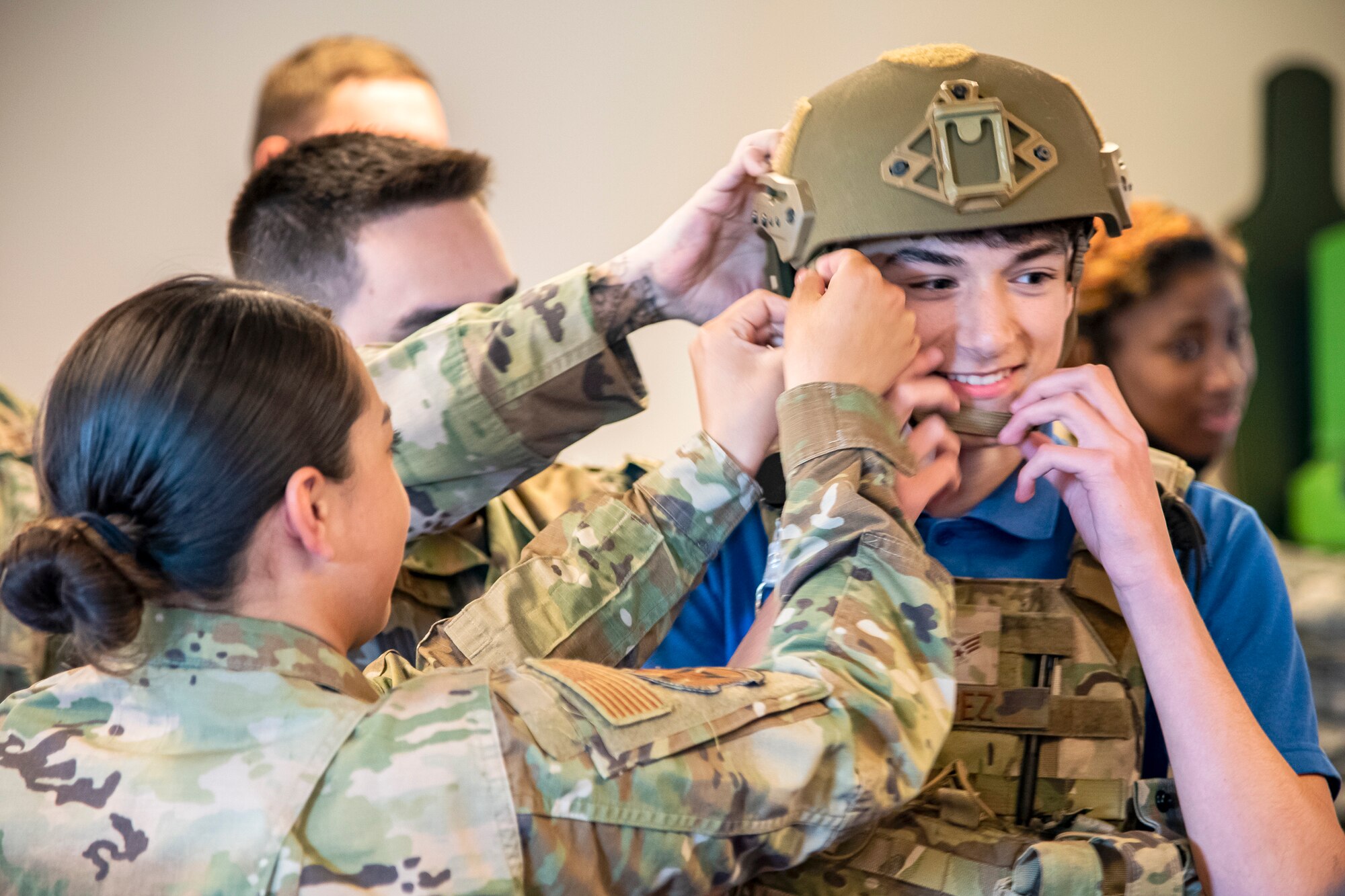 Airmen from the 423d Security Forces Squadron, fit a helmet on a local UK student at RAF Molesworth, England, May 10, 2022. The 423d SFS taught students from Huntingdon’s St. Peter’s school about weapons safety and self defense techniques as part of a mentorship program aimed at strengthening the relationship between the 501st Combat Support Wing and local community. (U.S. Air Force photo by Staff Sgt. Eugene Oliver)