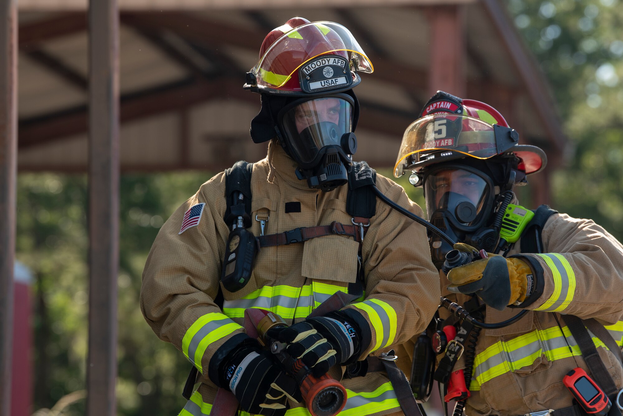 A photo of two people in fire fighter suits.