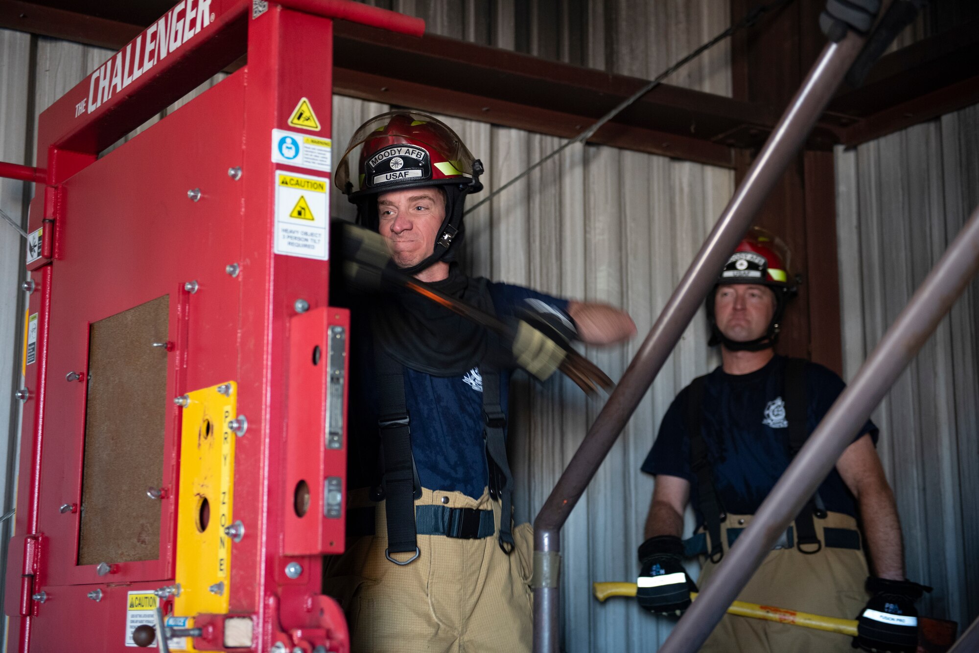 A photo of a man with a tool slamming into a mechanical door.