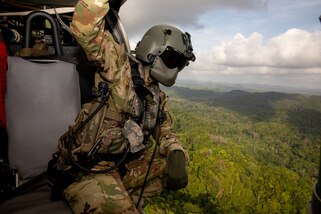 U.S. Army Sgt. Matthew Lynch, a flight paramedic assigned 1st Battalion 228th Aviation Regiment, checks for airborne contacts during a medical evacuation exercise over Belize City, Belize.