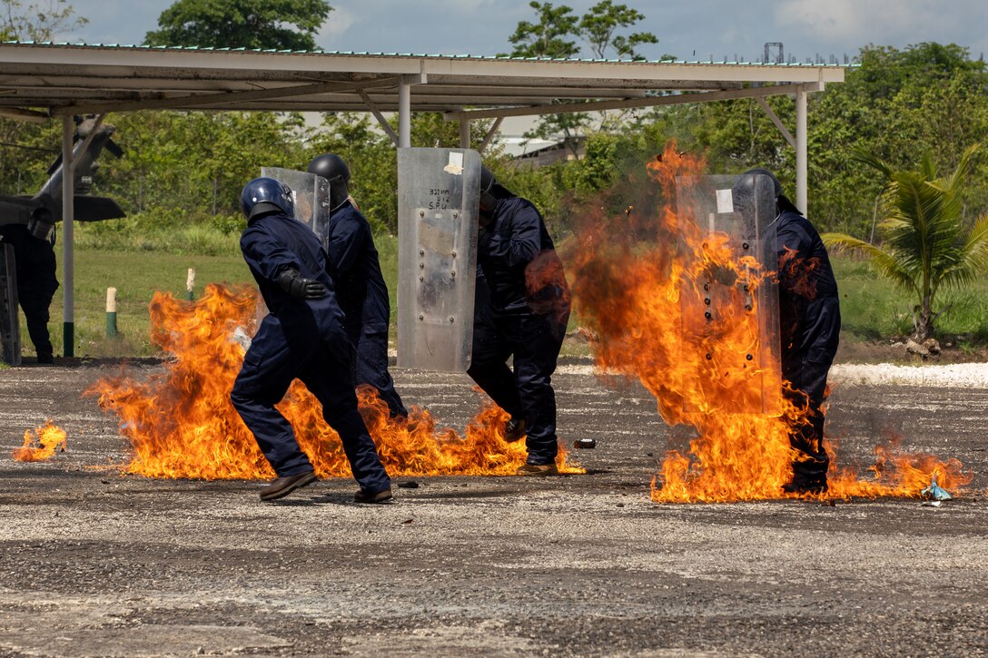 Police officers and service members from various partnering nations conduct public order and counter petrol bomb training lead by the Royal Bermuda Regiment at the Belmopan Police Training Academy.